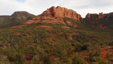 aerial: rocky mountain valley with forest at grasshopper point, sedona - drone flying shot