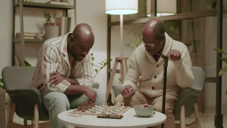 black men playing chess in the living room