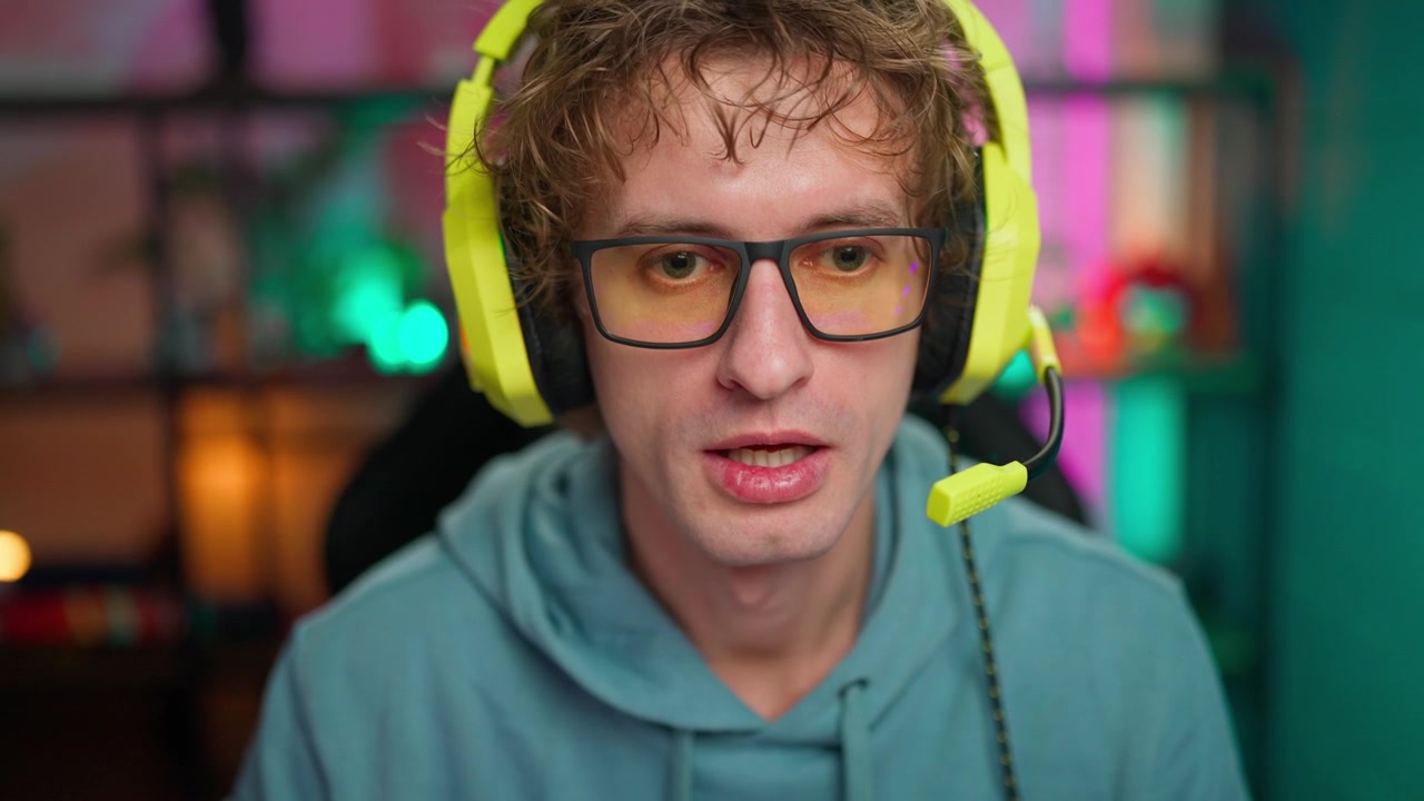 Mladý muž s náhlavní soupravou a brýlemi mluví do kamery