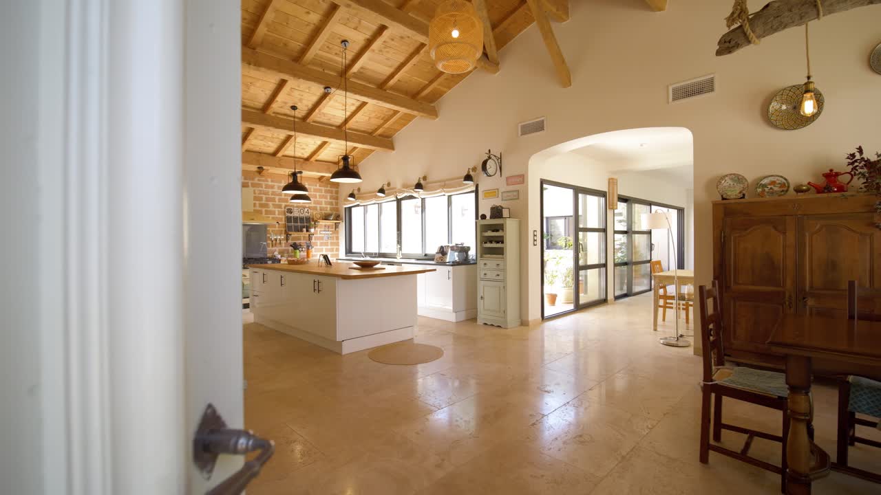 Slow dolly shot revealing a large open plan kitchen within a villa in france