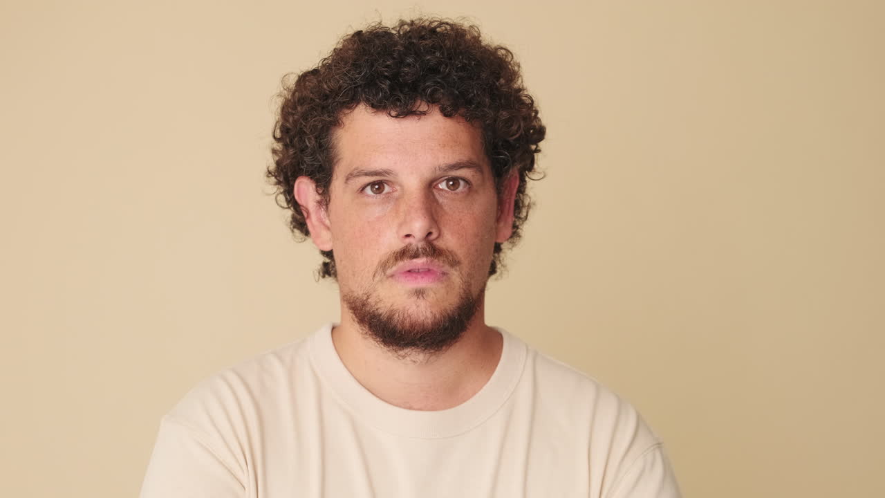 Man Reacts with Surprise and Happiness on Beige Background