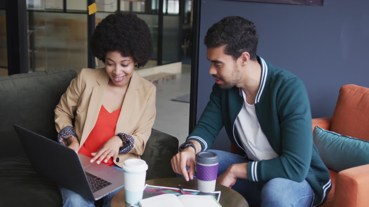 diversas personas de negocios sentadas haciendo papeleo usando una computadora portátil en una oficina moderna