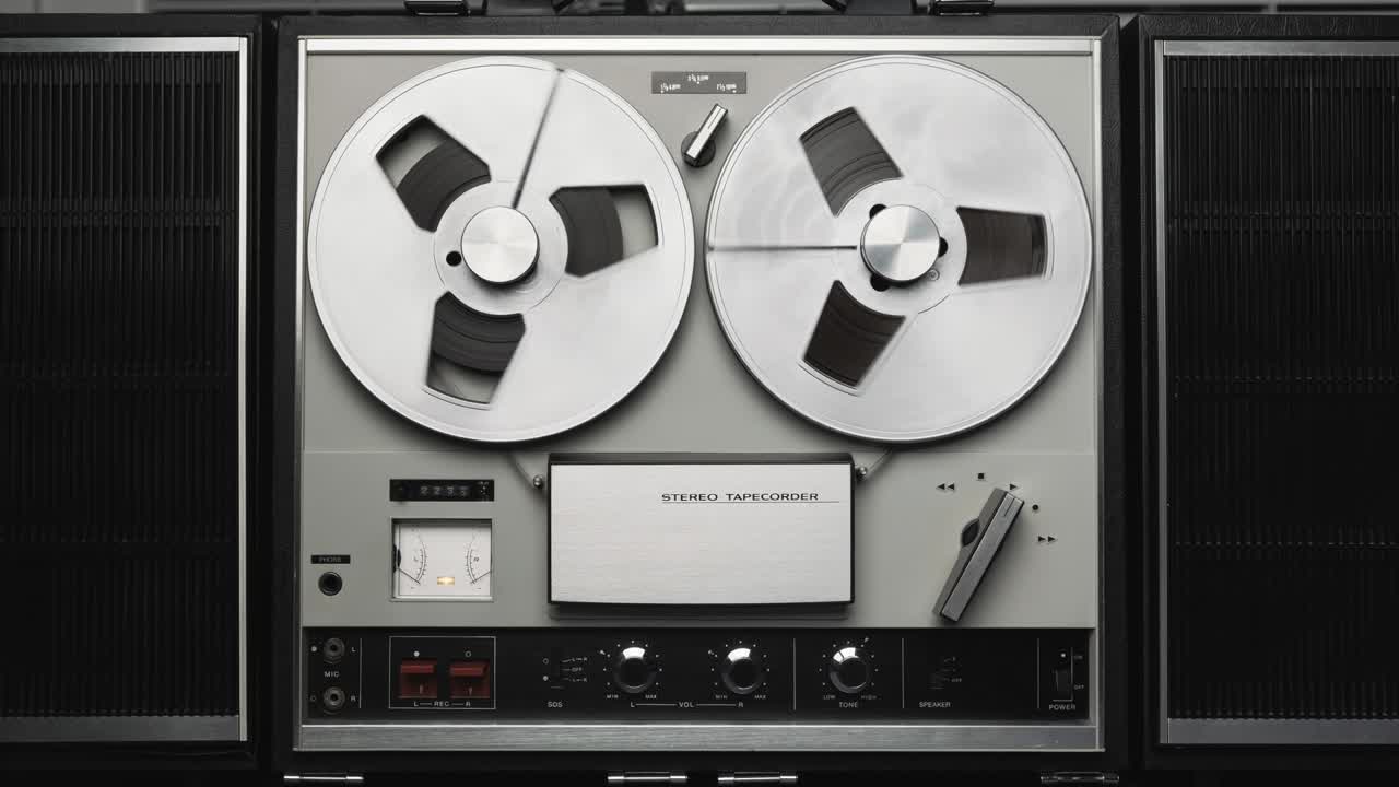 릴 테이프 레코더 재생. 릴 회전 빈티지 음악 플레이어 근접. 레트로 테이프. 회전 릴 금속 색. 파티. 루프. 전면 뷰. 전방 뷰. 인기 디스코 트렌드 60s, 70s, 80s, 90s.