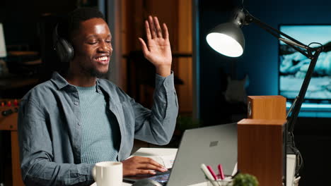 african american guy waving at a video call connection with workmates