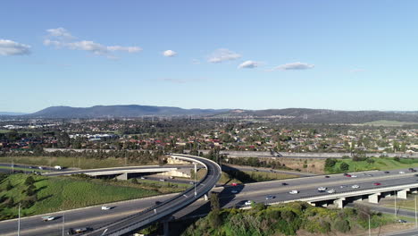 Slow-accent-over-Eastlink-highway-on-summer-afternoon-while-a-flock-of-birds-fly-around-the-drone