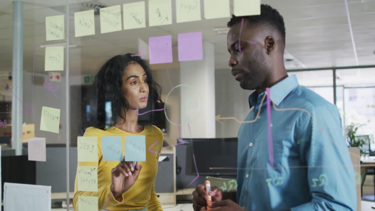Video of happy diverse businessman and businesswoman brainstorming