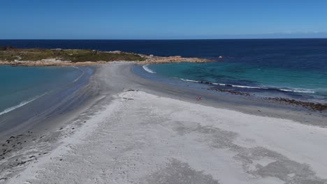 walking people along sandy beach of bicheno city in tasmania