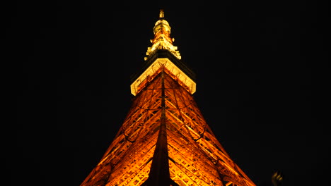 tilt up shot, under the tokyo tower, at night time, in minato, japan
