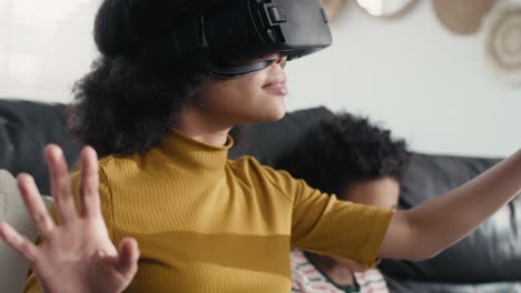 adolescente que usa un simulador de realidad virtual para jugar videojuegos en la sala de estar