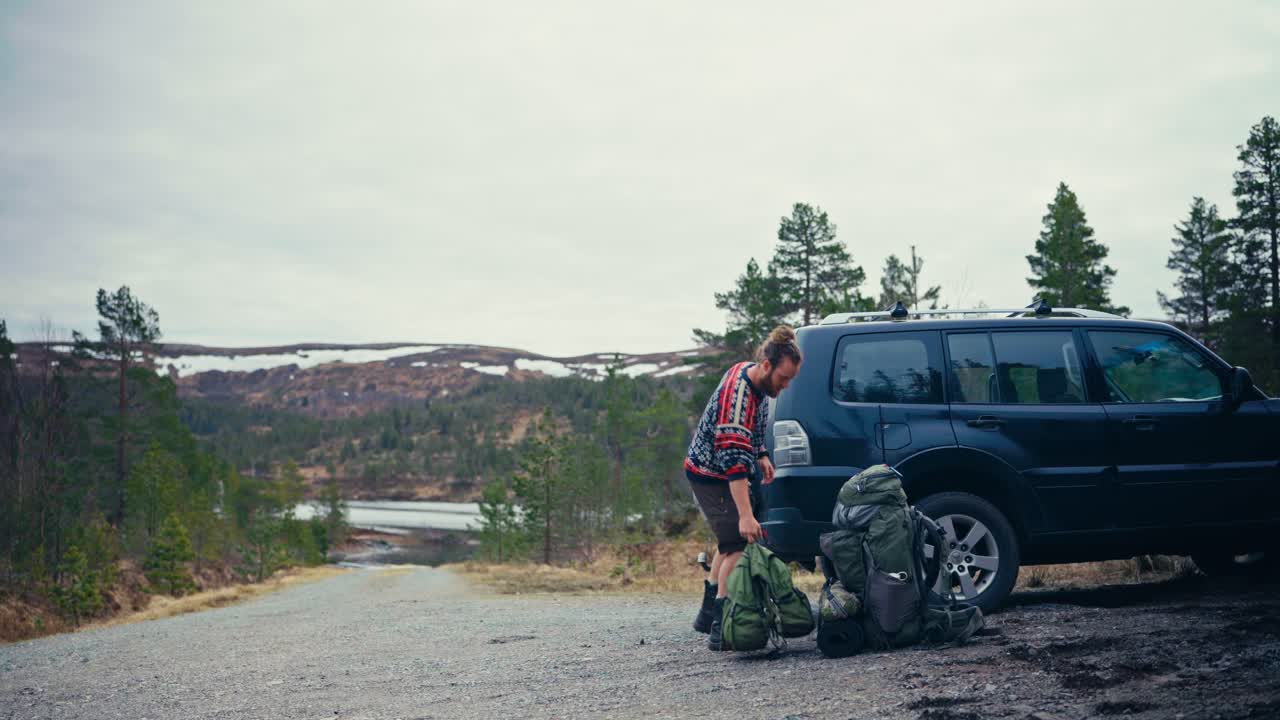 A Hiker Places His Backpack on the Ground Near the Shore of Reinsjøen in Åfjord, Trøndelag, Norway - Static Shot
