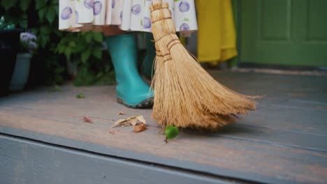 Frau-Trägt-Ein-Kleid-Mit-Gummistiefeln,-Die-Den-Boden-Fegen