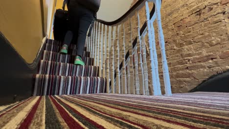 traveler dragging heavy luggage downstairs