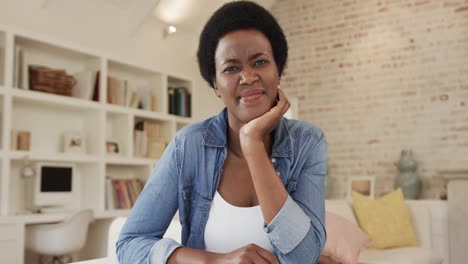 happy african american woman making video call in living room at home, slow motion