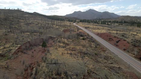 Drone-tracking-forward-through-trees-and-along-a-remote-mountain-road-in-the-Pike-National-Forest,-Rocky-Mountains,-Colorado