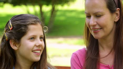 Mother-and-daughter-chatting-on-a-park-bench