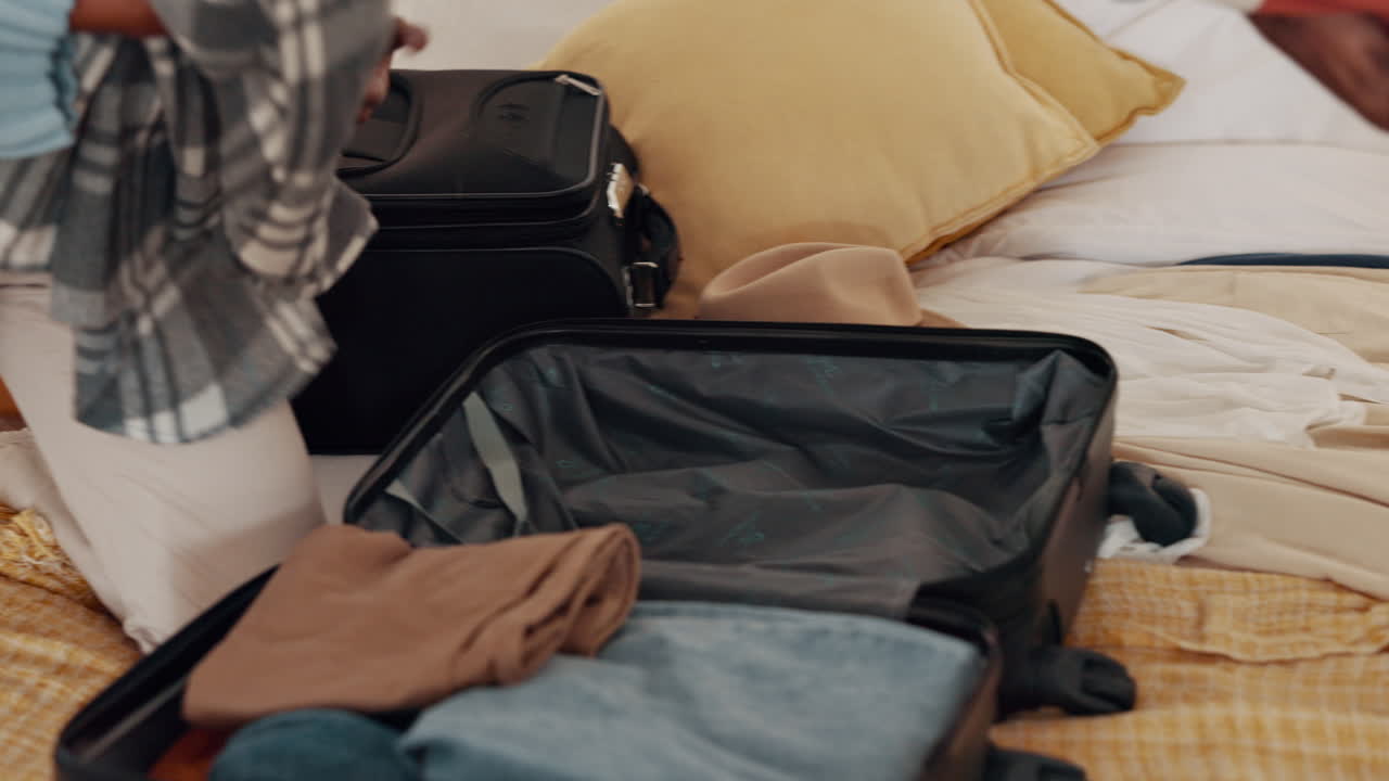 una pareja de manos empacando ropa de maleta