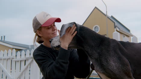 woman kissing a great dane dog