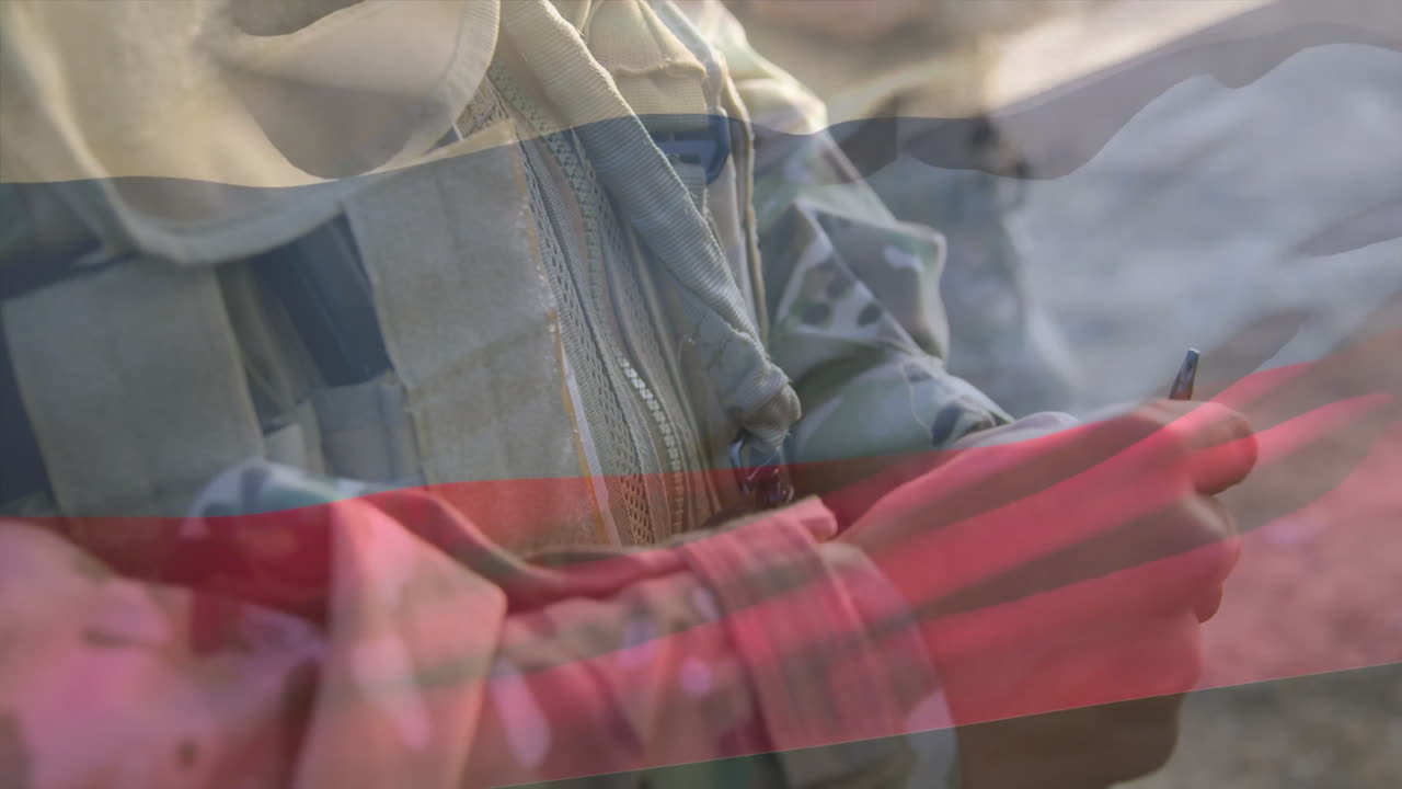 Holding rifle, military personnel in camouflage uniform standing over flag colors