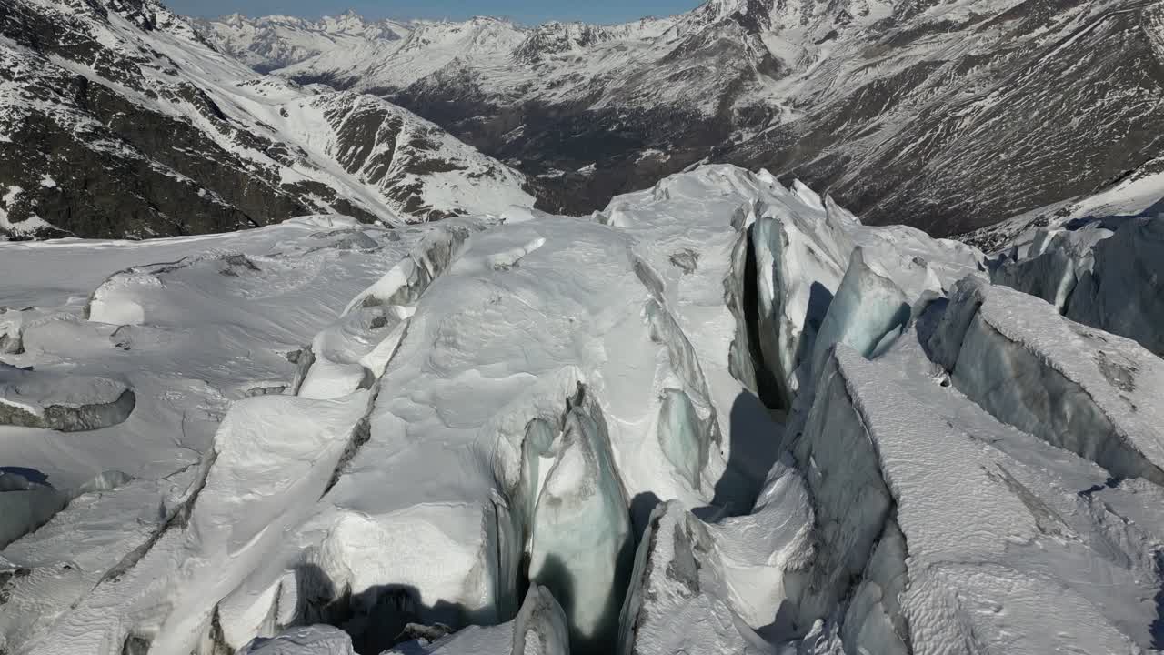empuje aéreo: fachada de montaña nevada en los alpes, rocas y picos nevados