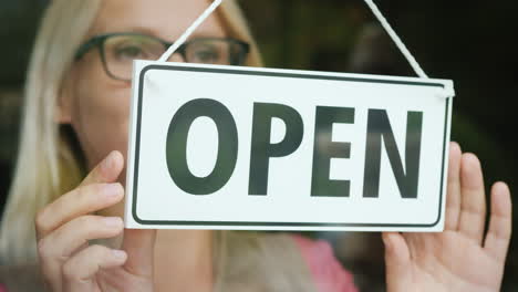 The-Female-Seller-Turns-The-Tablet-That-Says-Closed-To-Open-Beginning-Of-The-Day-Open-Your-Business-