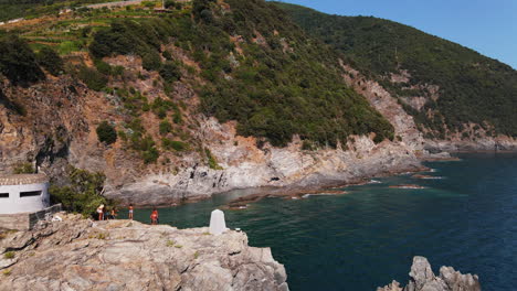 Overhead-view-of-a-group-of-man-and-woman-standing-at-cliff-edge-enjoying-a-relaxing-and-adventurous-vacation-in-Portovenere-Village-in-Italy