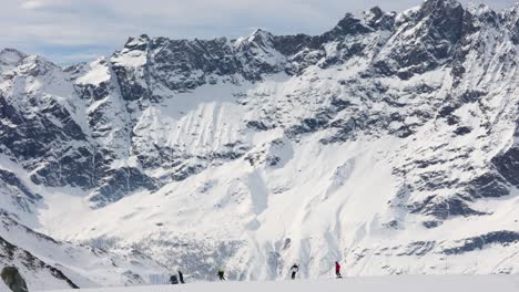 Skifahrer-Fahren-Im-Skigebiet-Der-Italienischen-Alpen-Mit-Epischer-Felsiger-Gebirgskette-Im-Hintergrund,-Cervinia