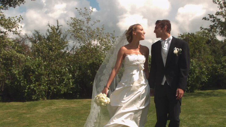 Newlywed couple walking and kissing