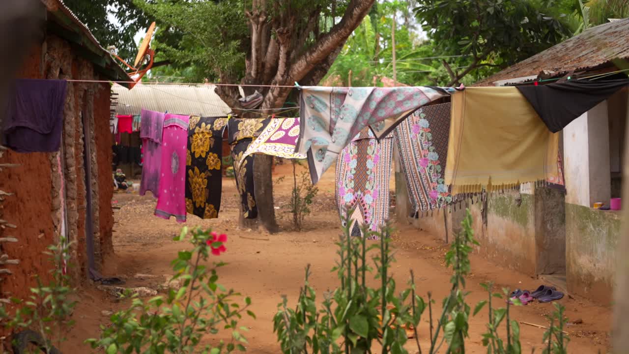 Traditional clothes hanging on washing line between rural houses in Kenyan village