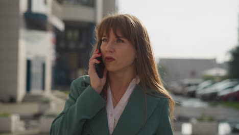 discontented young businesswoman talks on phone angrily