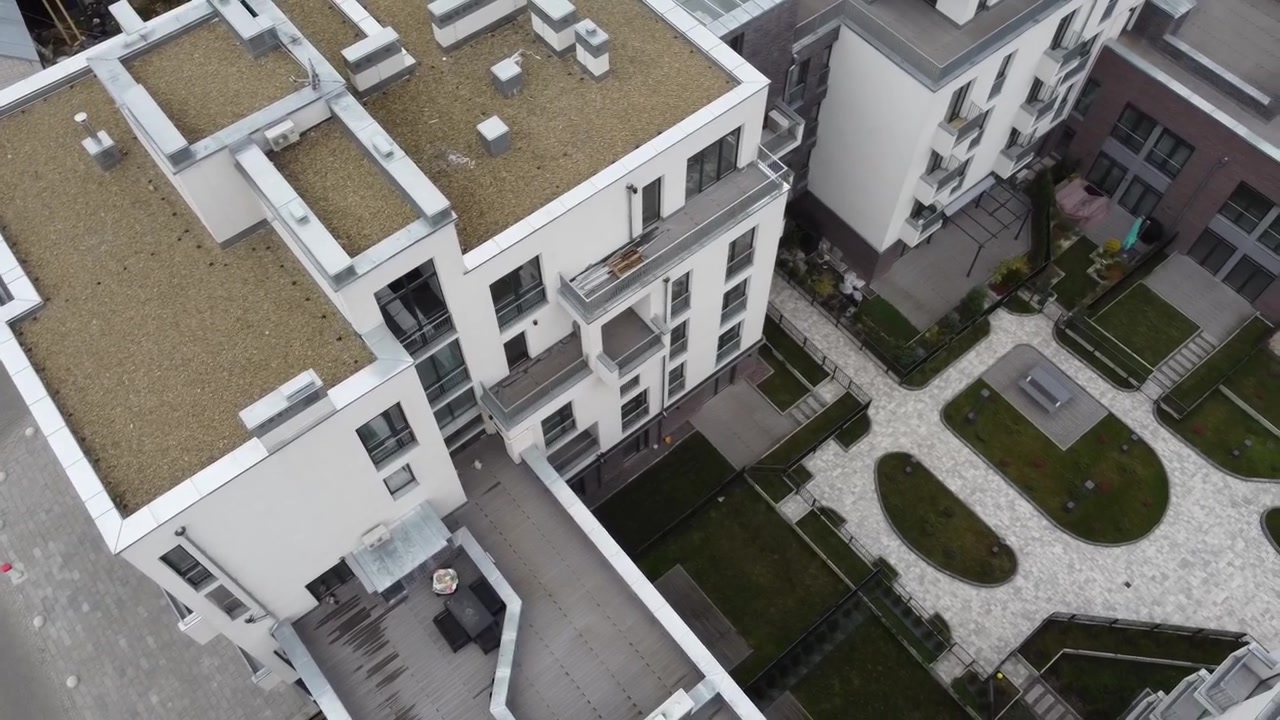 Luftfoto af en drone, der flyver over boligbygningerne og vejen.