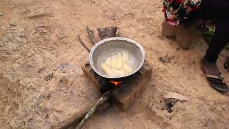 hirviendo plantanes en una olla con fuego de leña