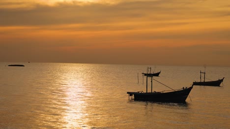 boats silhouetted against a vibrant sunset