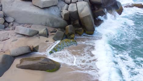 Enormous-Boulders-on-Shore-Break-Waves-Crashing-on-Tropical-Beach