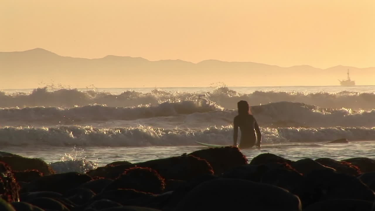 un surfista se mete en el océano 1