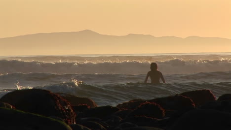 un surfista se mete en el océano 1