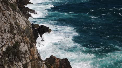 Fuertes-Olas-Chocan-Contra-Acantilados-Rocosos-Con-Marea-Alta,-Tiro-A-Cámara-Lenta