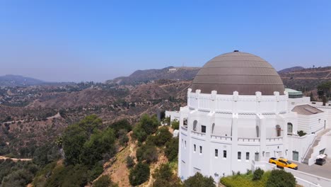 aerial past the griffith park observatory reveals hollywood sign in distance los angeles california