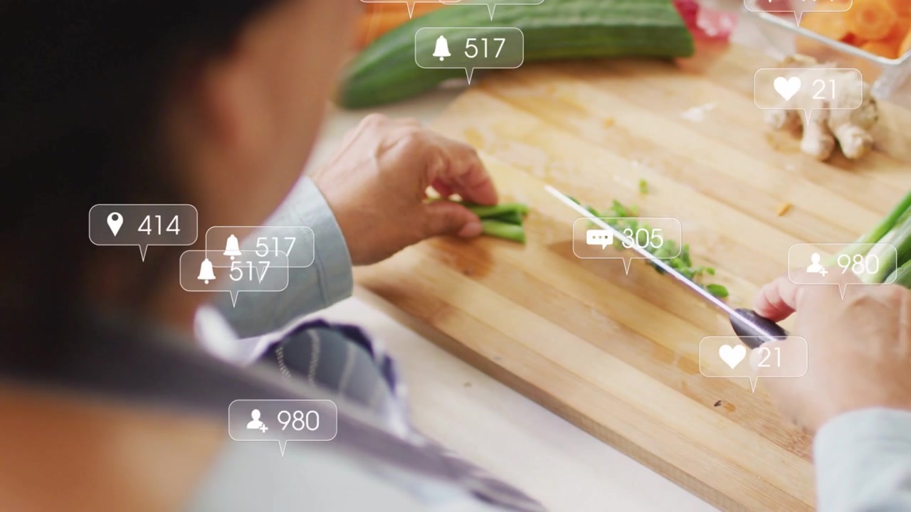 Cook chopping scallions on board, steadying hand and causing rising reaction bubbles for creators