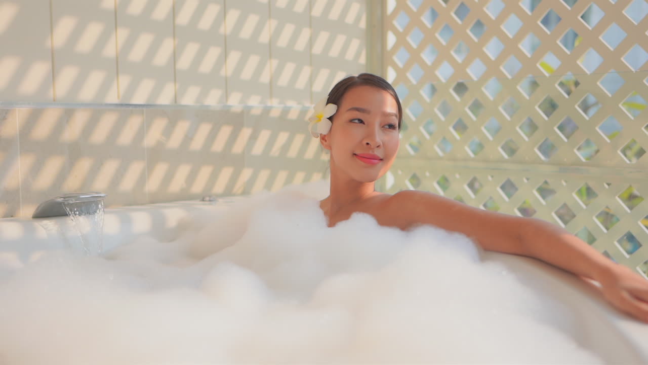 Soothing foam soap bath being enjoyed by asian young woman