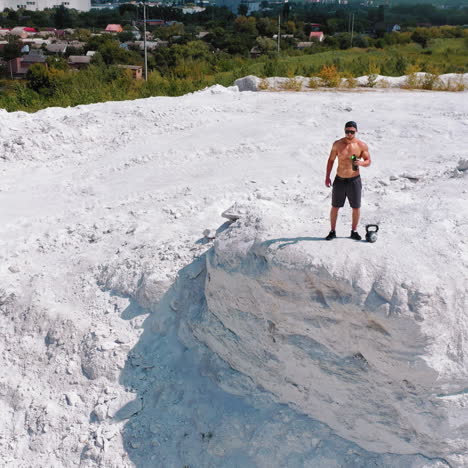 man working out with kettlebell in a quarry