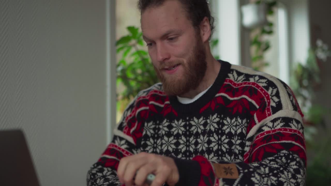 개인 노트북으로 집에서 일하는 수염을 가진 남자