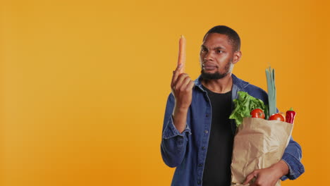 vegan guy looking closely at a carrot to ensure its best shape