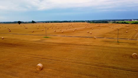 aerial view of a large industrial brown field with many hay bales in 4k