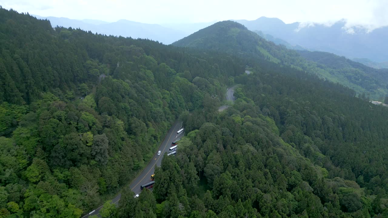 A winding road through the lush, green alishan national forest, taiwan, aerial view