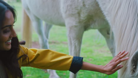 mujer, cuidado y mano en el caballo con una sonrisa