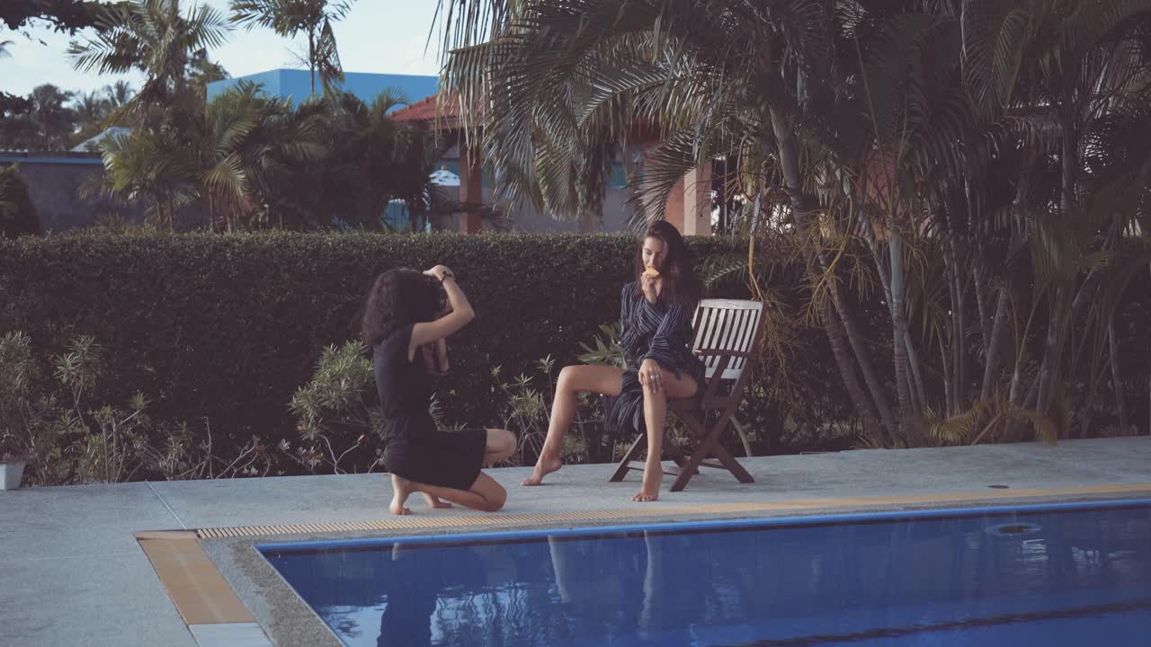 Model Posing and Eating Fruit During Outdoor Photoshoot by Pool