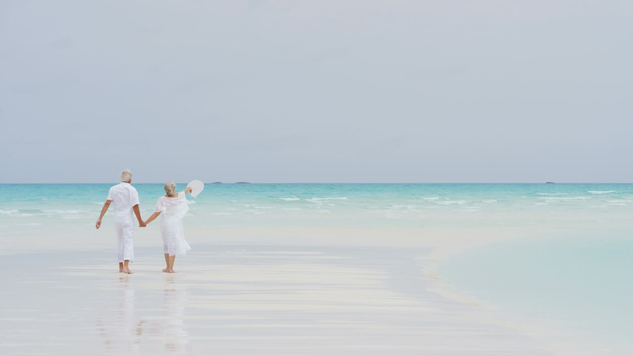 고령 백인 부부가 섬 해변에서 함께 고 있습니다.