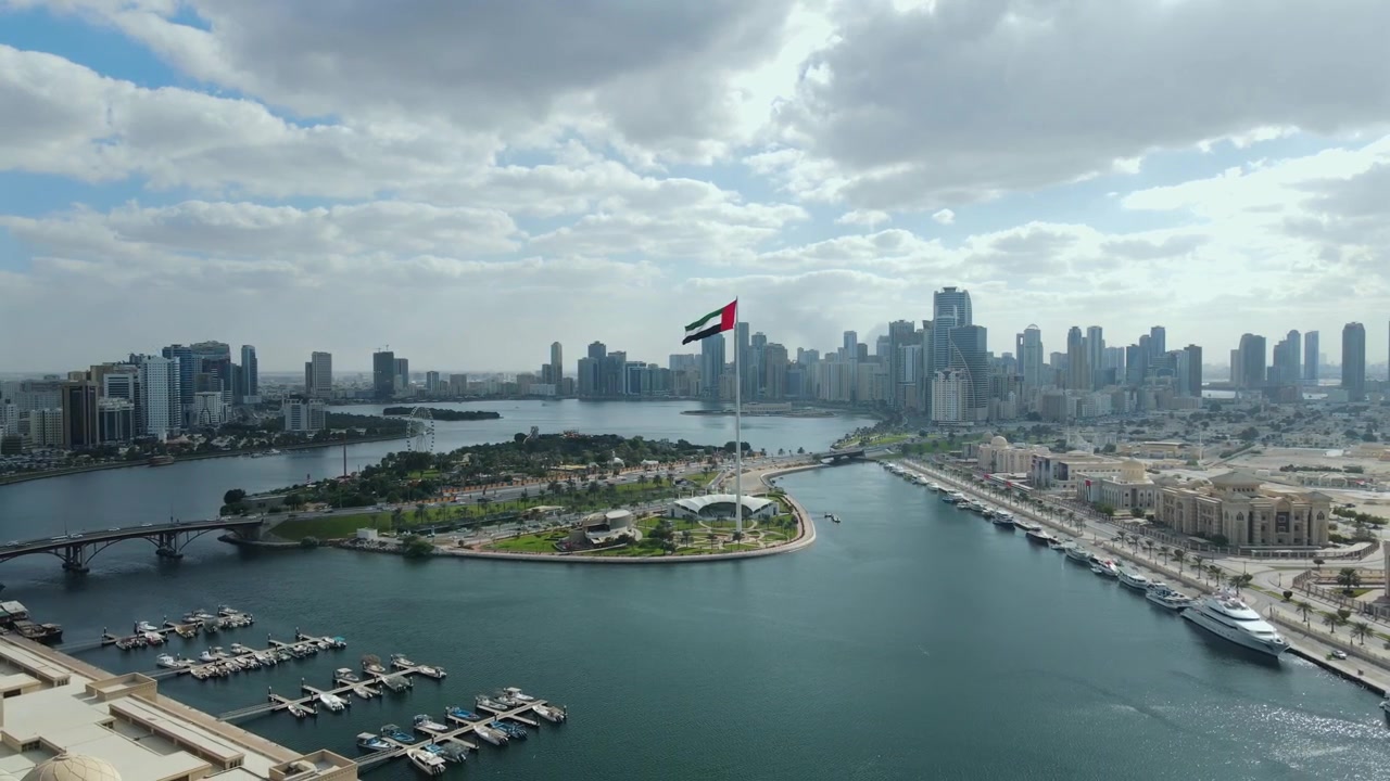 A giant UAE flag waves over the city of Sharjah, United Arab Emirates.
