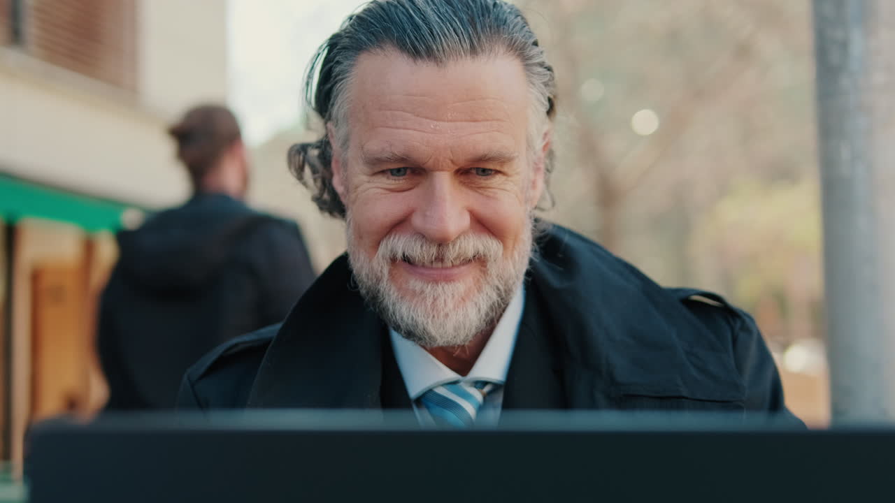 Smiling Businessman Working on Laptop Outdoors