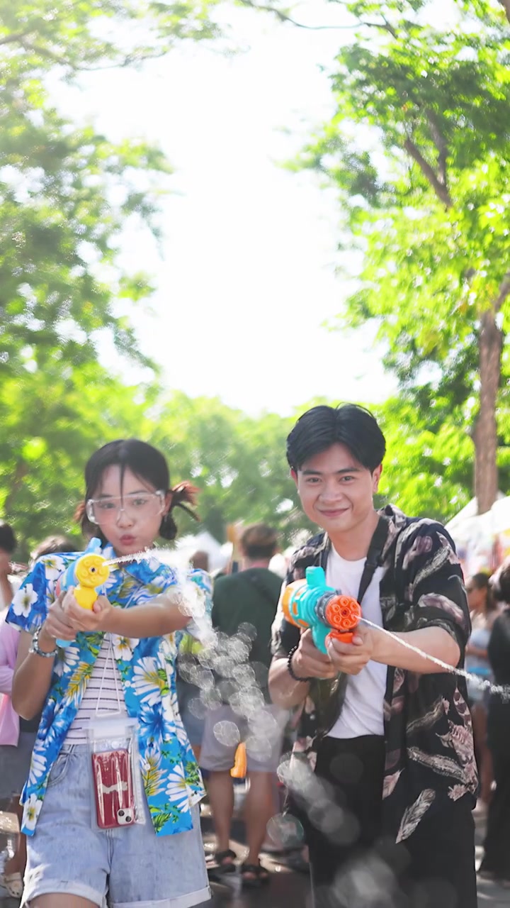 ソンクラーン祭りで水鉄砲を楽しむ若いカップル